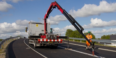 Autotransporter/Abschleppwagen mit knickarmigem Ladekran und Hebebalken, Abstützungen ausgefahren – ideal zum Verladen und Bergen von Fahrzeugen