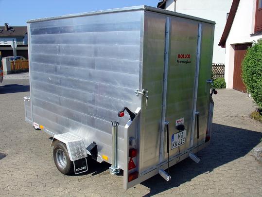 Einachsiger Aluminium-Kofferanhänger mit verriegelten Heckflügeltüren, Stützfüßen und Beleuchtung – robuster Transportanhänger für Umzug, Möbel und empfindliche Ware (DOLLCO Fahrzeugbau).