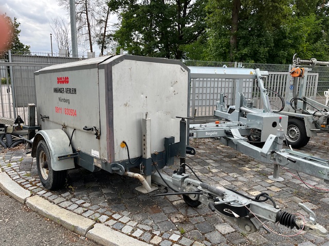 Gebrauchter, geschlossener Kofferanhänger – einachsig, verzinkter Aufbau mit Deichsel, Stützrad und Auflaufbremse; Mietanhänger vom DOLLCO Anhängerverleih in Nürnberg, ideal für Transport und Umzüge.