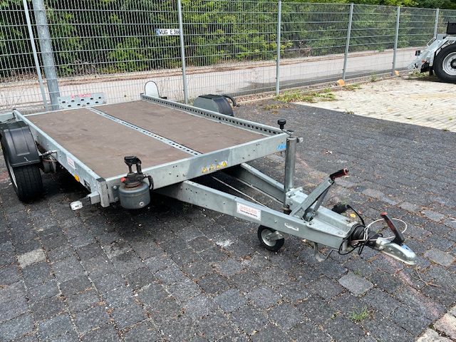 Flacher Motorradanhänger mit Zurrpunkten und Doppelachse – sicherer Transport von Motorrädern.